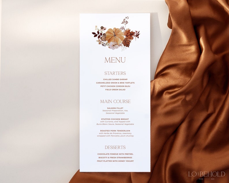 Op de afbeelding: Een witte menukaart met een herfstachtige illustratie van pompoenen, bladeren en bloemen in tinten oranje, bruin en geel. Het menu bevat een selectie van voorgerechten, hoofdgerechten en desserts. De tekst op de menukaart luidt "MENU", "STARTERS", "MAIN COURSE", "DESSERTS" en "LO BEHOLD".