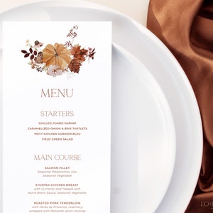 Op de afbeelding: Een herfstmenu met een aquarel-illustratie van pompoenen, bladeren en bessen. Het menu bevat voorgerechten en hoofdgerechten, waaronder gechilled jumbo garnalen, gekarameliseerde ui en brie-taartjes, petit chicken cordon bleu, veldsla, zalmfilet, gevulde kipfilet en geroosterde varkenshaas.