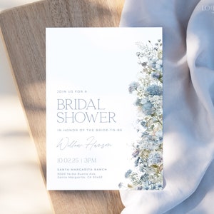 May include: A white bridal shower invitation with blue watercolor flowers on the right side. The text reads "Join us for a Bridal Shower in honor of the bride-to-be Willow Herson 10.02.25 | 3PM Santa Margarita Ranch 9000 Yerba Buena Ave, Santa Margarita, CA 93453"
