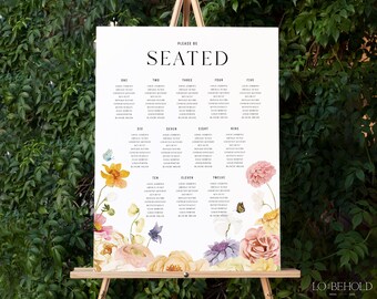 May include: A white wedding seating chart with a floral design. The chart is divided into twelve sections, each with a number and a list of names. The floral design features a variety of flowers, including roses, daisies, and butterflies.
