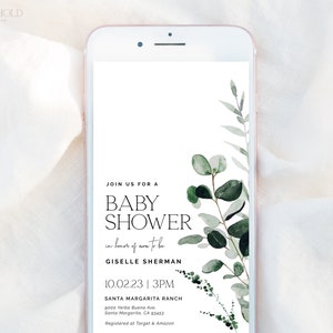May include: A smartphone screen displaying a baby shower invitation with a leafy green watercolor design. The invitation reads "Join us for a Baby Shower in honor of mom-to-be Giselle Sherman 10.02.23 | 3PM Santa Margarita Ranch 9000 Yerba Buena Ave. Santa Margarita, CA 93453 Registered at Target & Amazon"