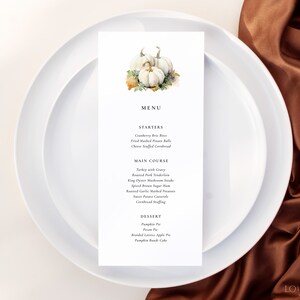 May include: A Thanksgiving menu with a watercolor illustration of white pumpkins. The menu includes starters, main course, and dessert options.