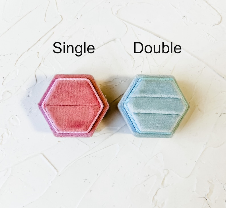 May include: Two velvet ring boxes, one pink and one light blue, with the words "Single" and "Double" printed above them.