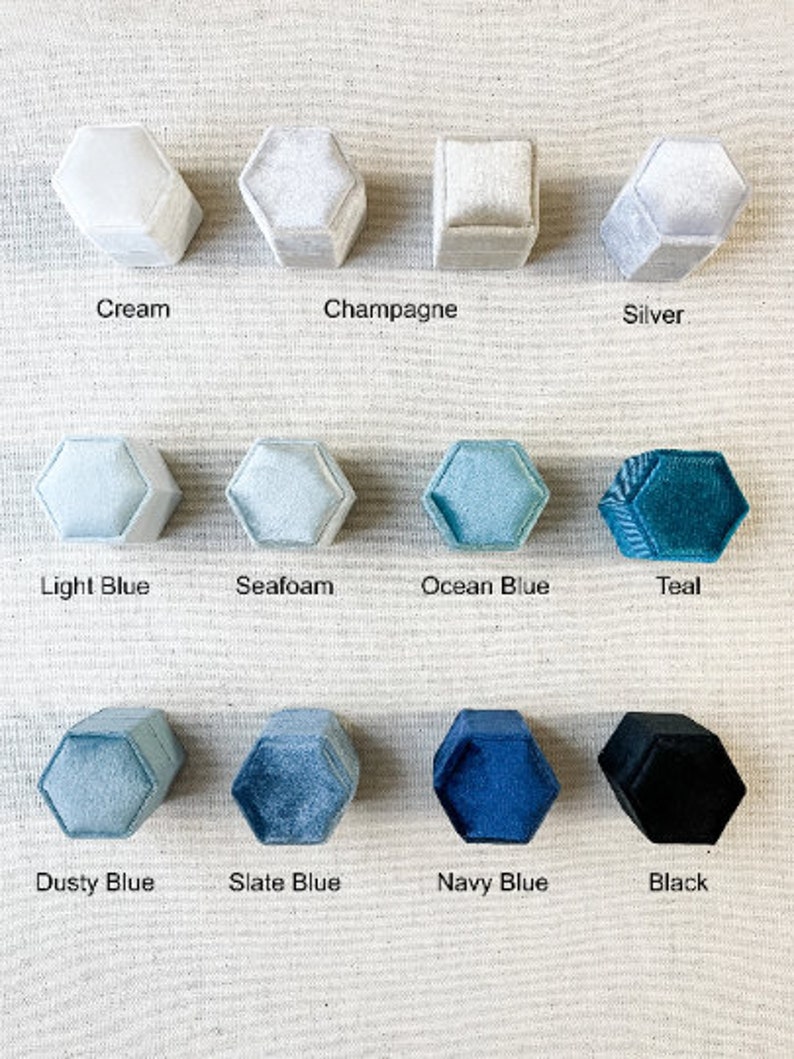 May include: Twelve hexagonal ring boxes in various colors, including cream, champagne, silver, light blue, seafoam, ocean blue, teal, dusty blue, slate blue, navy blue, and black.