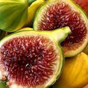 May include: Close-up of a sliced fig, revealing its deep red interior and seeds. The fig's green and yellow exterior contrasts with the vibrant inside. Other whole figs are visible, creating a still-life composition of fresh produce.