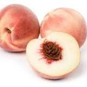 May include: Three peaches on a white background, one sliced in half. The peaches are a mix of red and pale yellow, with a fuzzy texture. The cut peach reveals a white interior and a brown pit.
