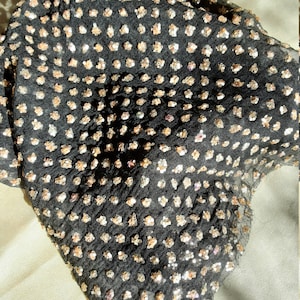 black muslin fabric decorated with dots of tiny gold sequins