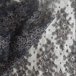 May include: Black lace trim with a delicate floral pattern. The lace has a slightly shimmery finish.