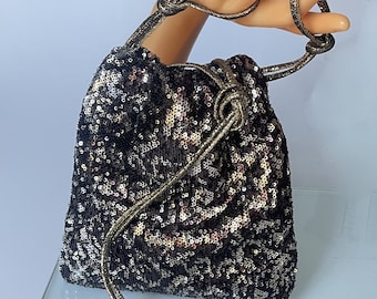 Small bon bon clutch purse, crossbody evening bucket bag in sequin fabric. Worn on the wrist, by hand, on the shoulder or as a bandolier.