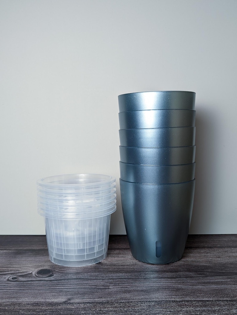 a stack of 6 metallic teal self watering pots. Metallic teal outer pot and clear inner pot sit next to each other.