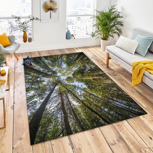 Puede incluir: Una alfombra verde y marrón con una imagen fotorrealista de un bosque desde un ángulo bajo, mirando hacia arriba a los árboles.