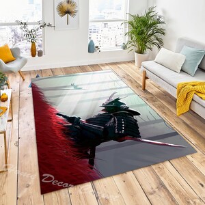May include: A gray and red area rug with a black and white illustration of a samurai warrior. The warrior is wearing a helmet and armor and is holding a sword. The background is a light gray with white lines.
