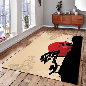 May include: A beige area rug with a black silhouette of a person standing on a hill with a red sun behind them. The hill has a large tree and a small structure on it. The rug has a floral pattern in the background.