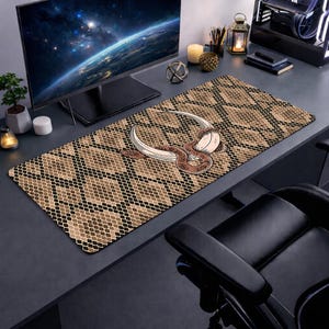 May include: A rectangular desk mat featuring a snake skin pattern in shades of brown and black. A detailed illustration of a snake with a curved blade is centered on the mat. The mat is designed to protect the desk surface.