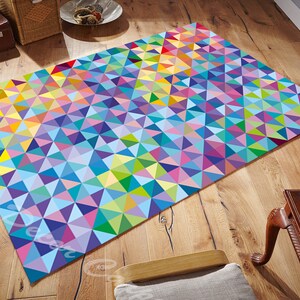 May include: A colourful geometric rug with a pattern of triangles in shades of blue, green, yellow, pink, and purple. The rug is made of a soft, durable material and is perfect for adding a touch of colour and style to any room.