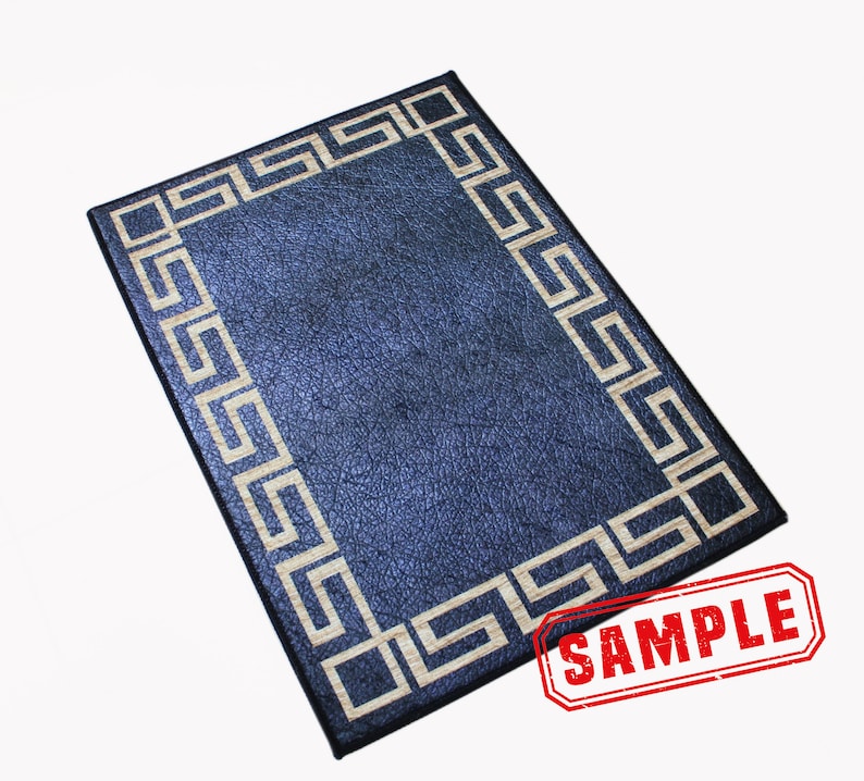 May include: A dark blue rectangular mat with a white Greek key border. The mat has a textured surface and the word "SAMPLE" is stamped in red on the bottom right corner.