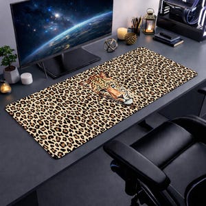 Könnte beinhalten: Ein rechteckiges Schreibtisch-Pad mit Leopardenmuster und einem Leopardenkopf-Motiv. Das Pad ist braun und beige mit schwarzen Flecken, geeignet für einen Computer. Abmessungen in Zentimetern.