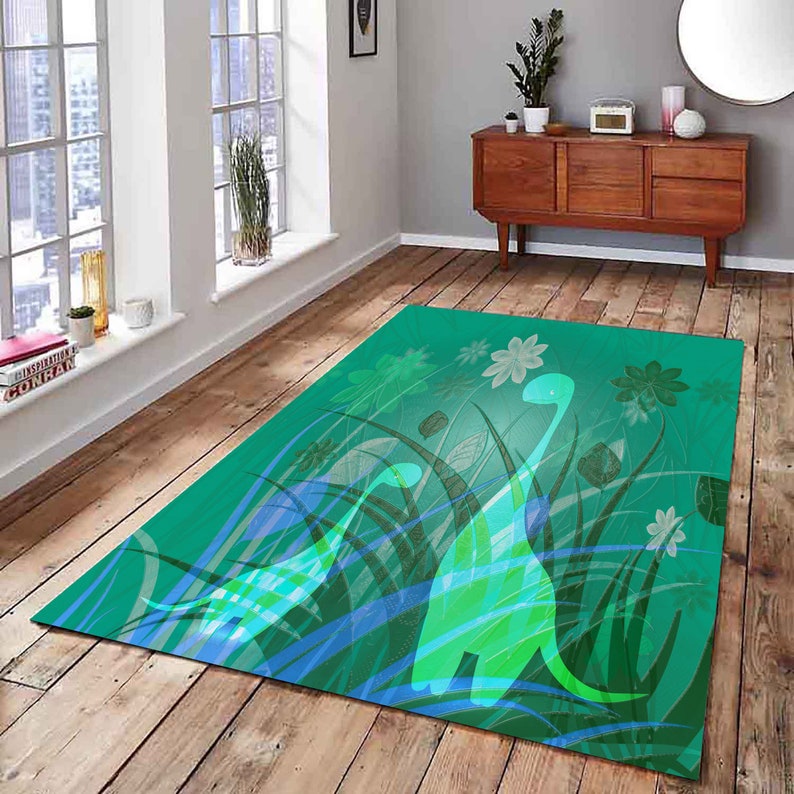 May include: A green rug with a design of two green dinosaurs in a field of green grass and blue flowers.