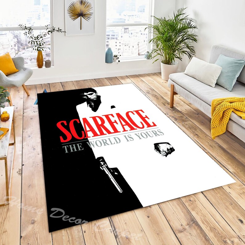 May include: Black and white rug with a silhouette of a man holding a gun. The text "Scarface" and "The World Is Yours" is printed in red on the rug.