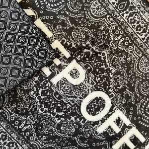 K&ouml;nnte beinhalten: Ein schwarz-wei&szlig;er Teppich mit einem detaillierten Paisley-Muster und dem Text "RIP OFF" in fetten wei&szlig;en Gro&szlig;buchstaben. Die Unterseite des Teppichs ist schwarz und weist ein strukturiertes, rutschfestes Gittermuster aus kleinen Quadraten und Punkten auf.