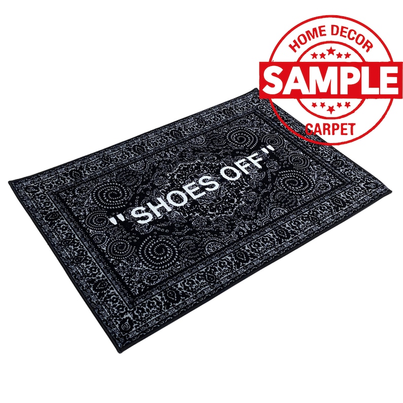 K&ouml;nnte beinhalten: Schwarz-wei&szlig;er Fu&szlig;abtreter mit Paisley-Muster und dem Text "Shoes Off" in Wei&szlig;.