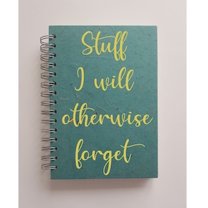 May include: A teal blue spiral bound notebook with the text "Stuff I will otherwise forget" written in yellow.