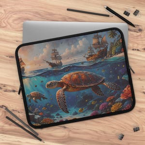 May include: A laptop sleeve featuring a colourful underwater scene with a large sea turtle swimming above a coral reef. The scene is split in half, with the top half showing a blue sky and three sailing ships.