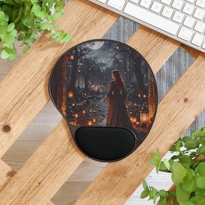 May include: A black mouse pad with a dark forest scene featuring a woman in a long dress walking through a path lit by lanterns. The scene is set at night with a full moon and stars in the sky.
