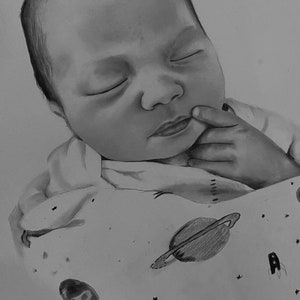 May include: A black and white pencil drawing of a sleeping baby. The baby is wrapped in a blanket with a space-themed pattern, including planets, stars, and a rocket ship. The baby's eyes are closed, and a finger rests near the mouth.