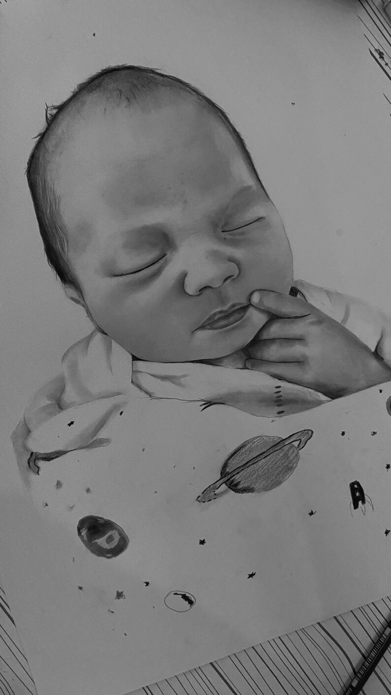 May include: A black and white pencil drawing of a sleeping baby. The baby is wrapped in a blanket with a space-themed pattern, including planets, stars, and a rocket ship. The baby's eyes are closed, and a finger rests near the mouth.
