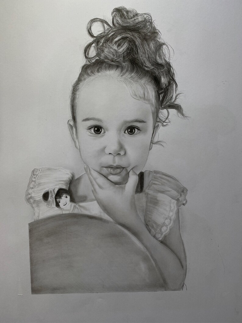 May include: A detailed pencil portrait of a young child with curly hair styled up. The child is looking directly at the viewer, with their hand gently touching their chin. The portrait is in grayscale, with soft shading and highlights.