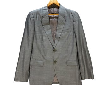 May include: A grey blazer with a two-button fastening and a single vent at the back.
