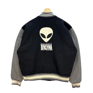 May include: A black and gray varsity jacket with a gray alien graphic and the text "BESCHWA" on the back.