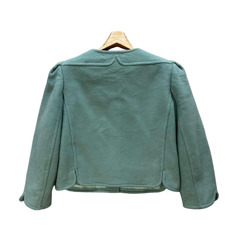 May include: A light green wool jacket with a slightly cropped length and long sleeves. The jacket has a simple design with a rounded collar and a button closure.