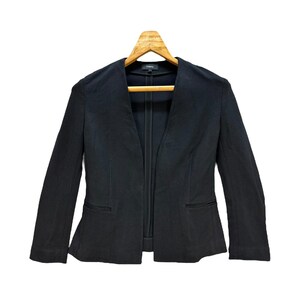 May include: A black open-front blazer with long sleeves and a collar. The blazer has a Theory label on the inside.