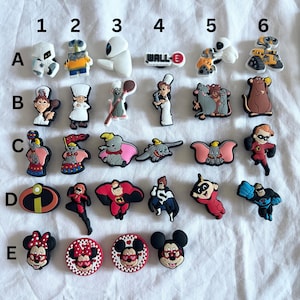 Peut inclure: Un ensemble de 25 breloques colorées pour chaussures représentant des personnages de films Disney et Pixar populaires, notamment Wall-E, Dumbo et les Indestructibles.