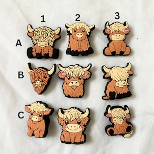May include: Nine brown and white Highland cow charms with different expressions. The charms are numbered 1 through 3 and lettered A through C.