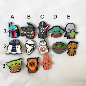 Peut inclure: Un ensemble de 12 breloques de chaussures colorées représentant des personnages de Star Wars. Les breloques représentent des personnages comme Yoda, Dark Vador, R2-D2 et Grogu.