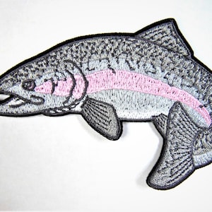 May include: A gray and pink embroidered iron-on patch of a rainbow trout fish.
