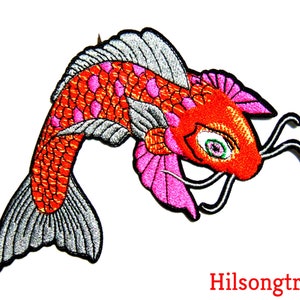 May include: Embroidered iron-on patch of a red and pink koi fish with silver scales. The fish has a green eye and a pink fin.