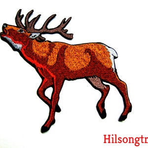 May include: Embroidered patch of a red deer with antlers, standing on all four legs with its head tilted back and mouth open, as if it is calling out. The deer is brown with a white patch on its rump.