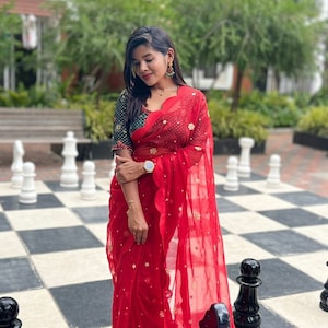 Red organza saree with greenish black handwork blouse