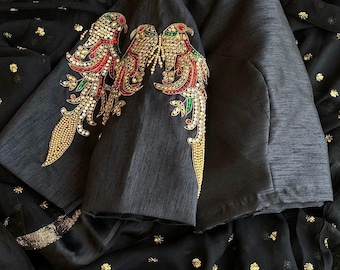 Blusa preta com bordado pesado e estampa de pássaro.