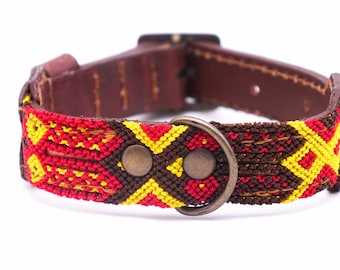 May include: A brown leather dog collar with a colorful woven pattern in red, yellow, and brown. The collar has a metal buckle and two metal rings.