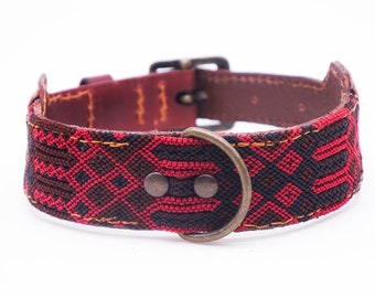May include: Red and black woven dog collar with a brown leather backing and a brass buckle.