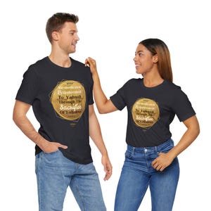 May include: Black t-shirts with a gold geometric design and text. The design includes the words "Re-dedicated & Redeemed To Yahuah Through The Sacrifice Of Yahshua". The shirts are worn by two people, one male and one female.