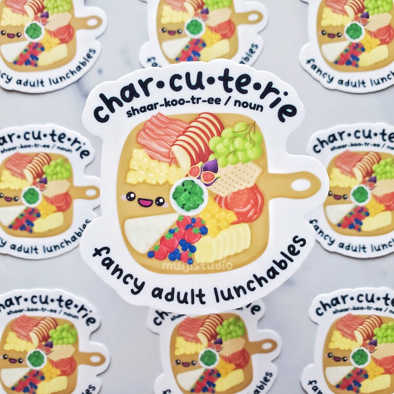 Pu&ograve; includere: Un adesivo bianco con un tagliere di salumi disegnato in stile cartoon con un viso sorridente. Il tagliere &egrave; pieno di vari cibi, tra cui formaggio, frutta, cracker e carne. Il testo sull'adesivo recita "char.cu.te.rie shaar-koo-tr-ee / noun fancy adult lunchables".