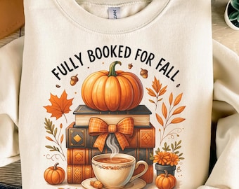 May include: Cream-colored sweatshirt with a fall-themed graphic. The design features a pumpkin atop books, a cup of coffee, and the text "FULLY BOOKED FOR FALL". Decorative elements include leaves and pumpkins.