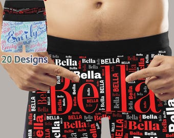 Könnte beinhalten: Schwarze Boxershorts mit einem roten und weißen Muster des Namens "Bella", das sich über die gesamte Oberfläche wiederholt. Der Text "20 Designs" ist auf dem Bild zu sehen.