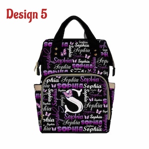 K&ouml;nnte beinhalten: Schwarze Wickeltasche mit einem lila und wei&szlig;en Schmetterlingsmuster und dem Namen "Sophia", der sich wiederholt. Die Tasche hat eine gro&szlig;e Fronttasche mit einem schwarzen "S" und einem Schmetterling.